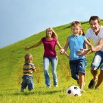 Children and parents play ball in nature