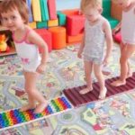 Children walk on colorful massage mats