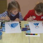 Two girls draw girls in blue dresses